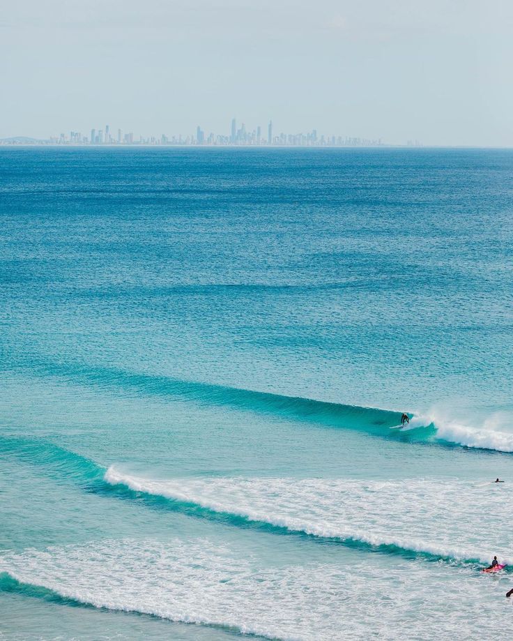 A clean wave peeling at Kirra Beach with the Gold Coast skyline on the horizon