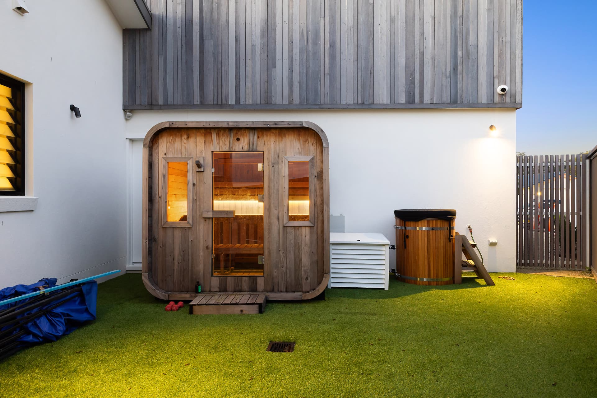 Cedar sauna and timber ice bath on the lawn beside the house